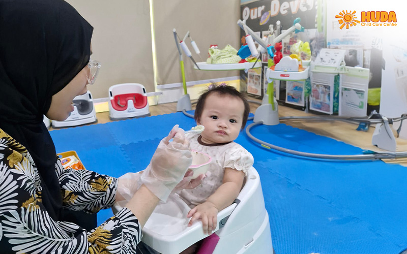 Infant educator feeding infant healthy food